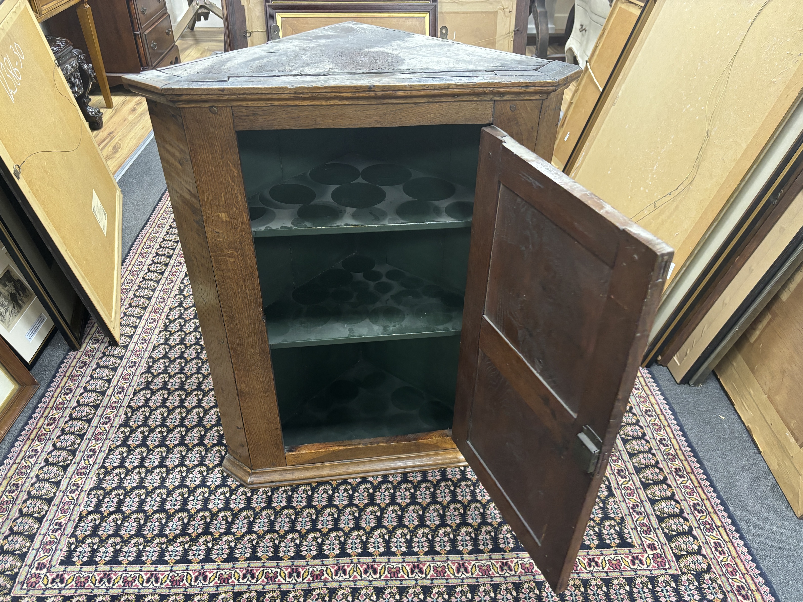 A late 18th century oak hanging corner cupboard, enclosed by a fielded panelled door, width 66cm, depth 38cm, height 85cm